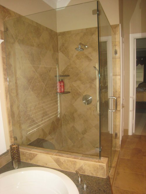 Walk-in shower with sleek tiling and frameless glass, designed to enhance comfort and modern bathroom style.
